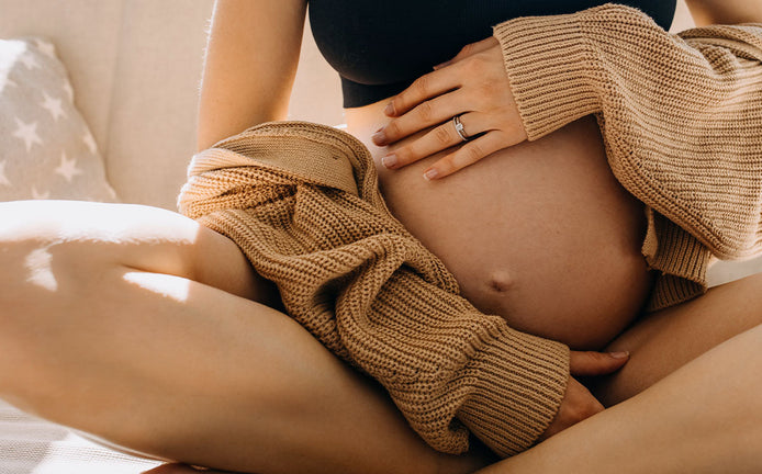 Ventre rond de femme enceinte avec une main posé dessus